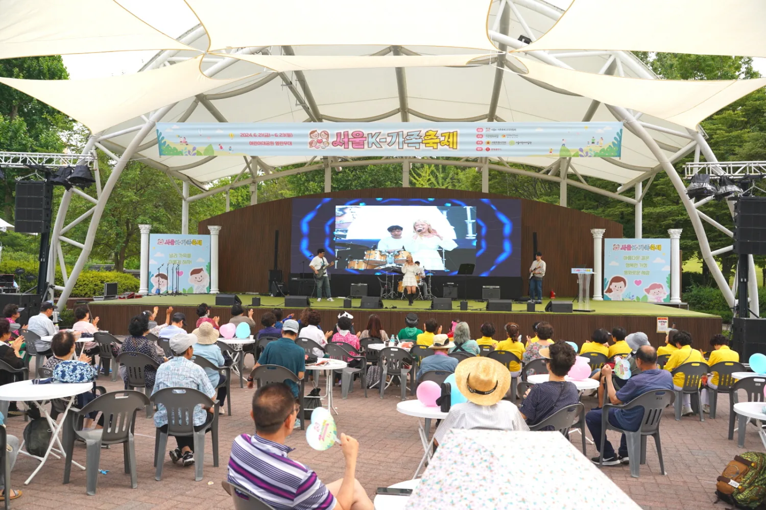 2024년 제2회 서울 K-가족축제 개최 안내 현수막이 걸린 서울 어린이대공원 열린무대의 공연 현장과 객석