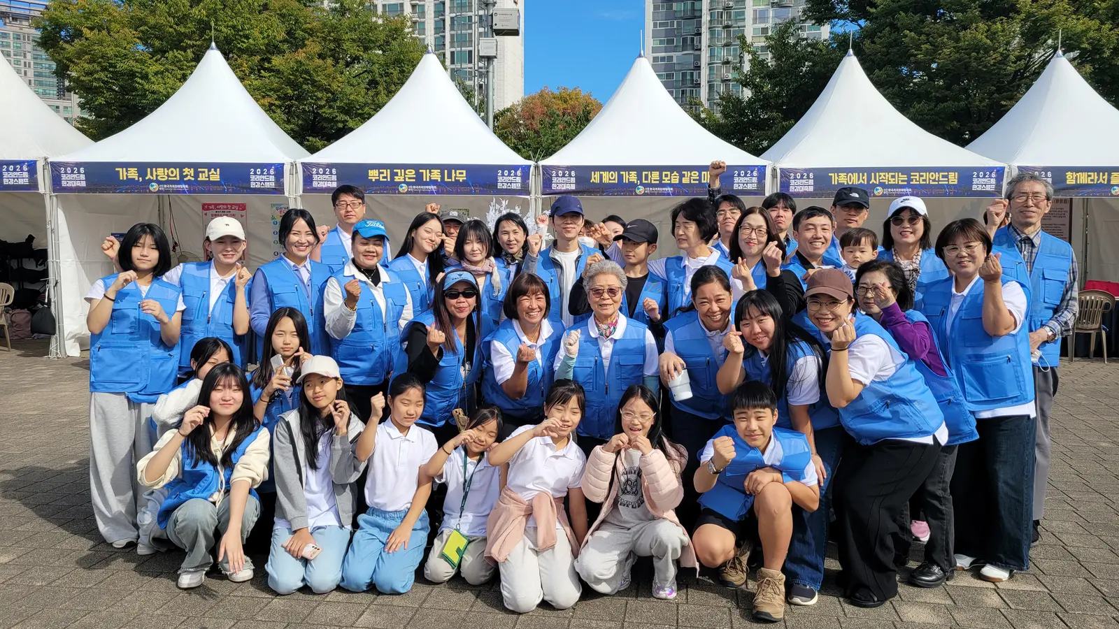 ‘2026 코리안드림 한강대축제’ K-가족가치존 부스 앞에서 파란 조끼를 입은 K-가족봉사단 어린이와 부모, 조부모가 함께한 단체사진