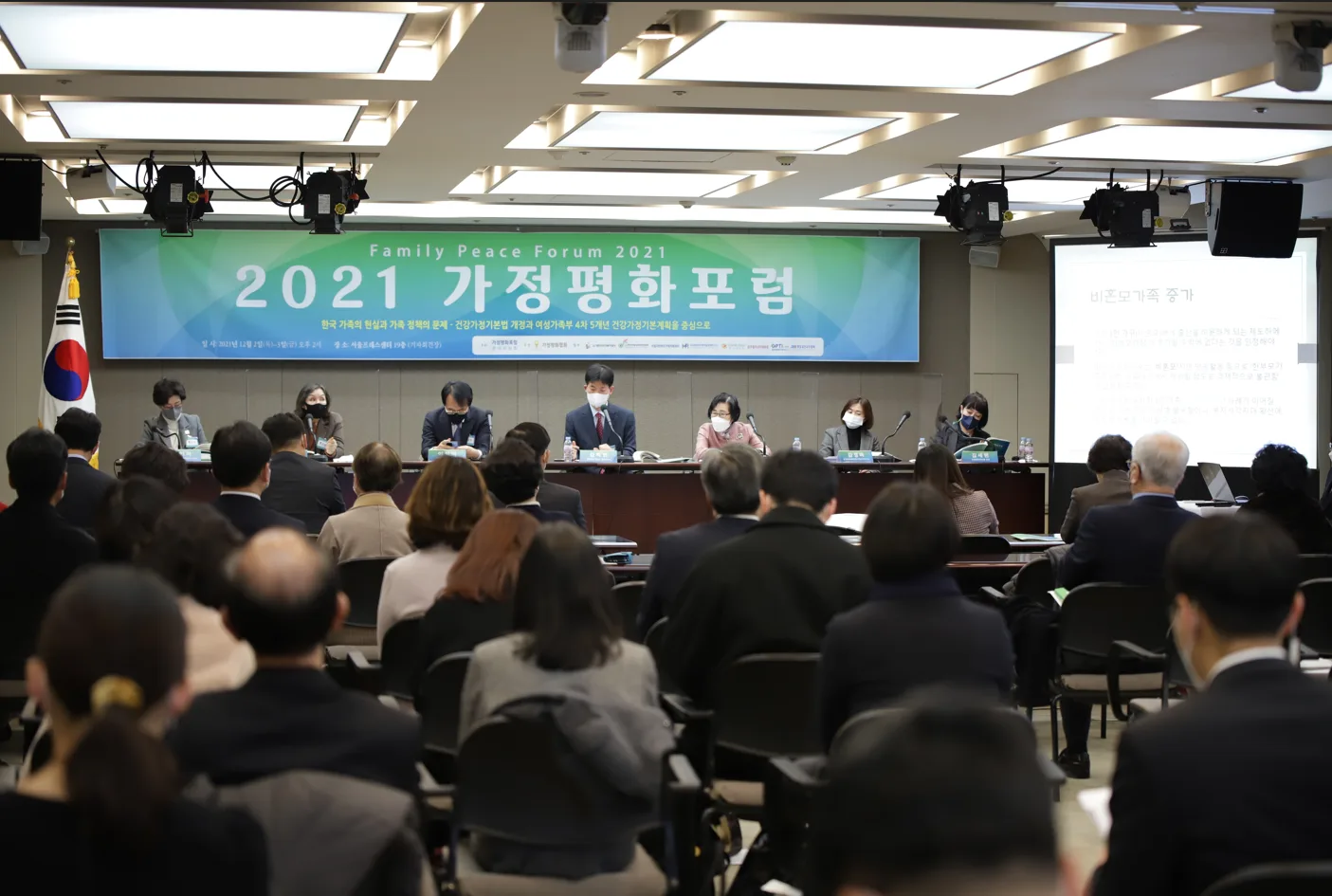 2021년 12월 제1회 가정평화포럼 '한국 가족의 현실과 가족 정책의 문제' 현수막 아래 서울프레스센터에서 발표를 듣는 참석자들
